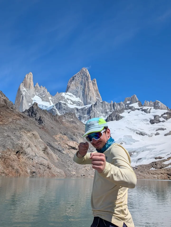 Davide beside a mountain lake, with Fitz Roy rising behind him