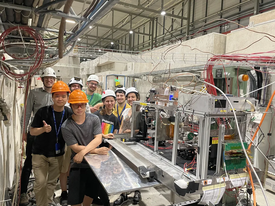 The PICOSEC test-beam team beside their detector setup in the experimental hall