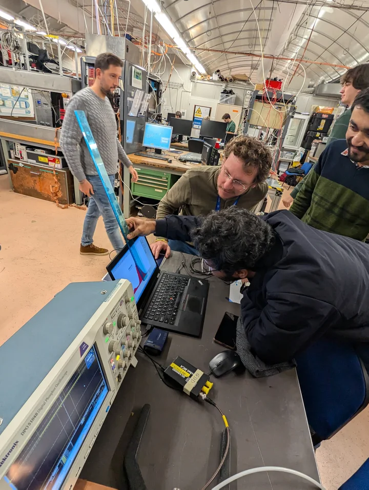 A detector-school laboratory session, with participants examining an instrument at the bench